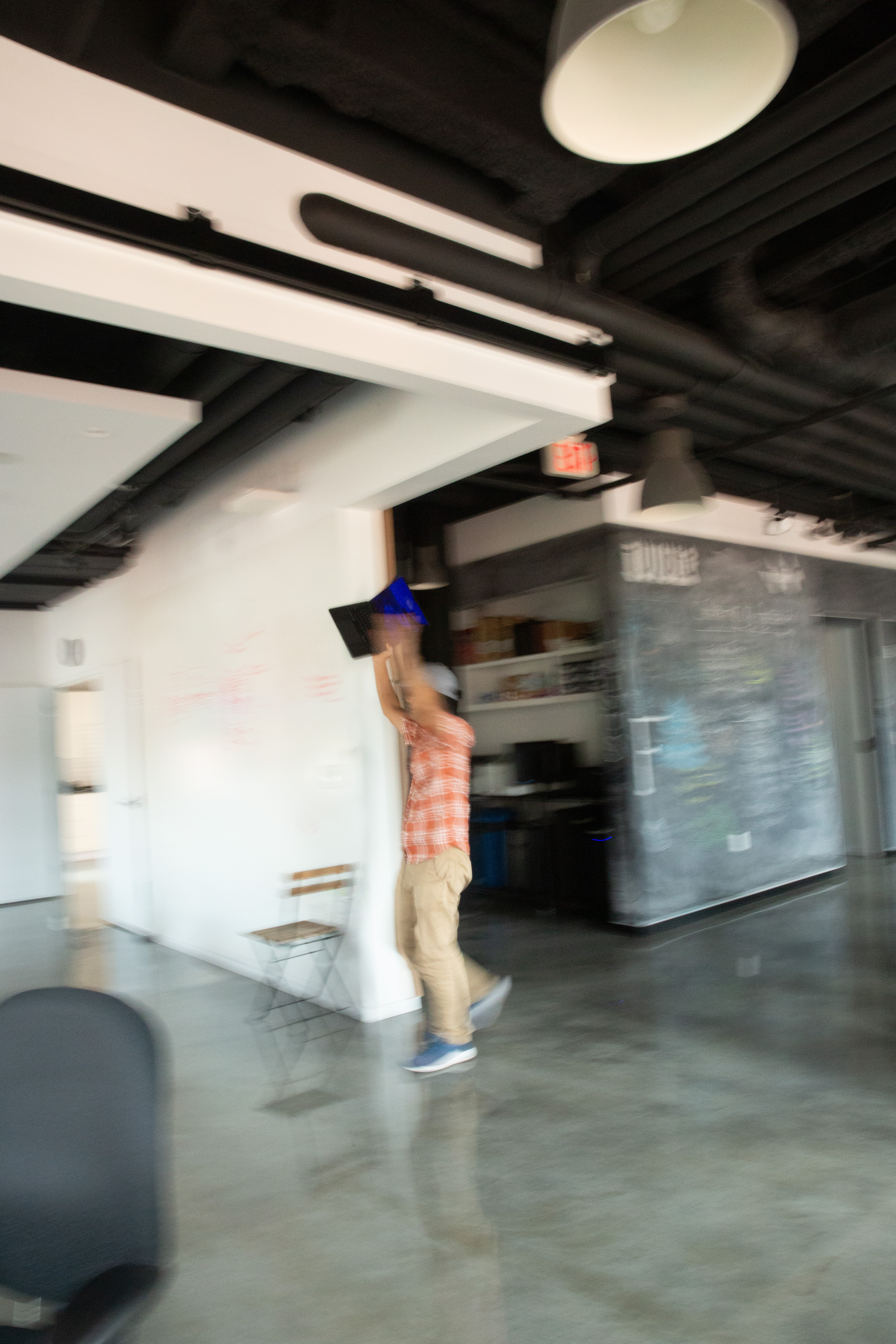 A blurry shot of Kyle running through the Fathom office with a laptop held over his head. 