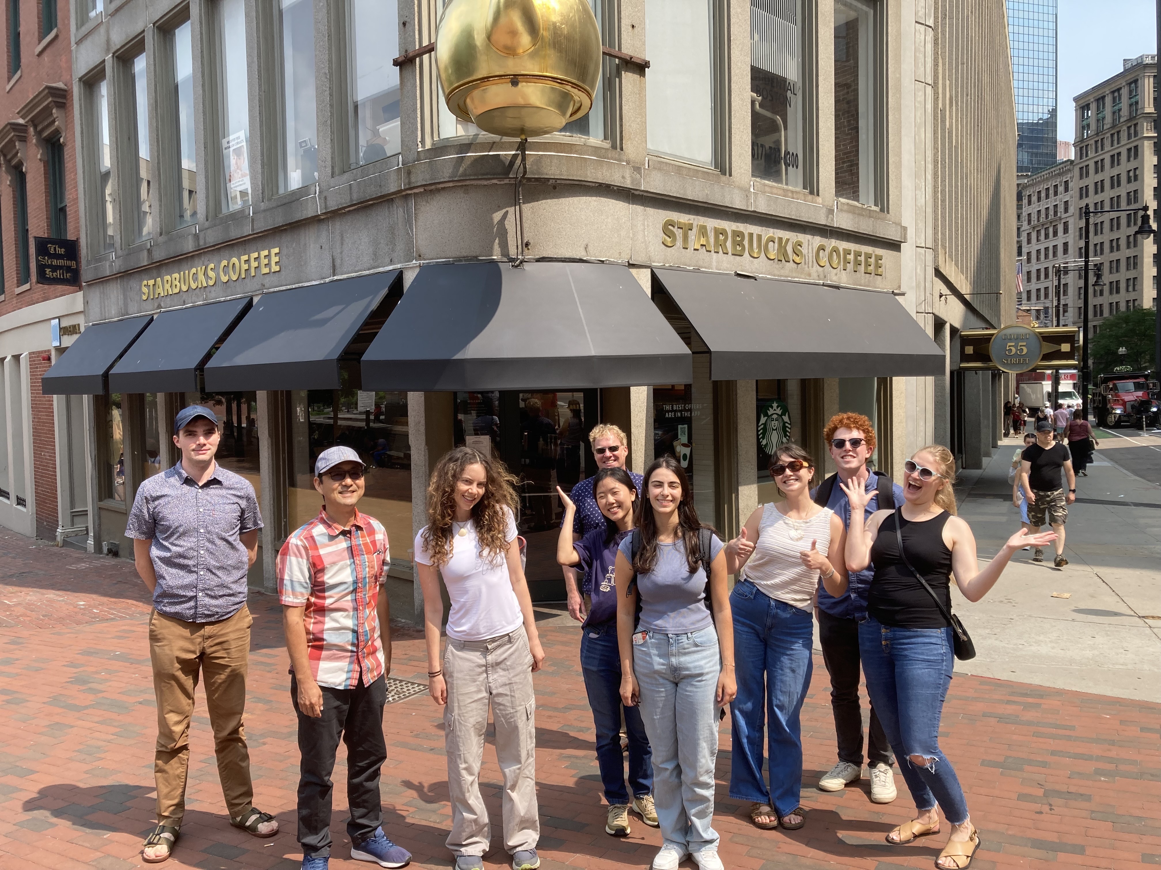 The Fathom team (minus Mark) documented in a group photo. They stand in front of an iconic Boston Starbucks that boasts a giant golden tea kettle.